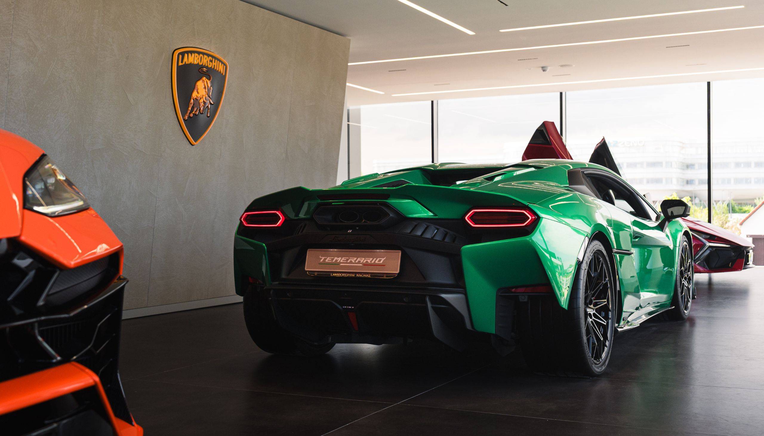 Lamborghini Knokke: showroom met strakke plafondverlichting en materiaalwand